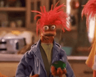 Red-Haired Muppet In Blue Jacket Holding Green Jar GIF