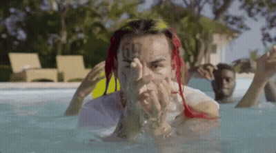 Red-Haired Tattooed Man Laying In Pool GIF