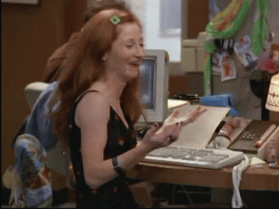 Red-Haired Woman At Desk With Paper GIF