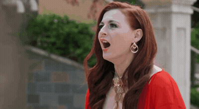 Red-Haired Woman In Earrings And Red Dress GIF