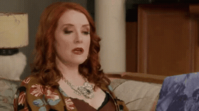 Red-Haired Woman In Floral Jacket And Necklace GIF