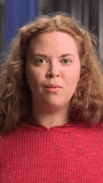 Red-Haired Woman In Red Sweater Making Face GIF