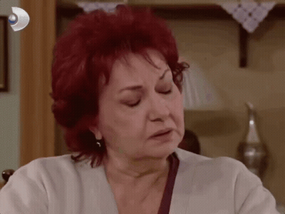 Red-Haired Woman Sitting Before Wall With Picture GIF