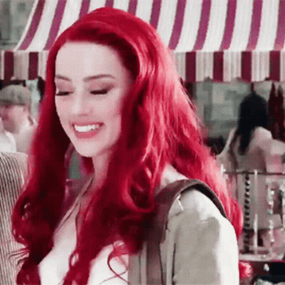 Red-Haired Woman Smiling At Striped Canopy GIF