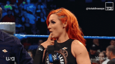 Red-Haired Woman Talking To Man In Wrestling Ring Wearing Black Lab Top GIF