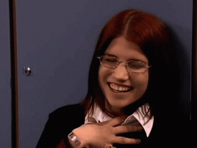 Red-Haired Woman With Glasses Smiling At Blue Locker GIF