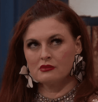 Red-Haired Woman With Necklace Earrings Making Funny Face GIF