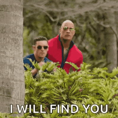 Red Jacket Man And Blue Shirt Man Behind Bush GIF