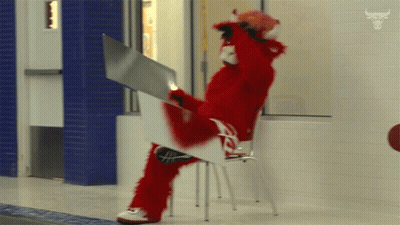 Red Mascot Sitting On Chair Holding White Board GIF