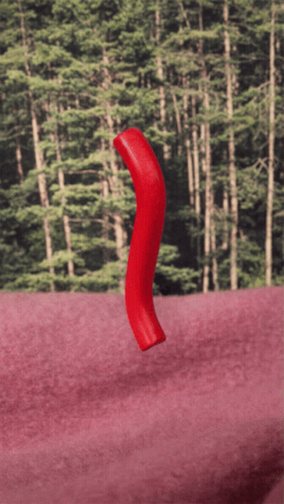 Red Object Floating On Pink Surface In Front Of Forest GIF