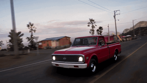 Red Pickup Truck Driving Down Road GIF