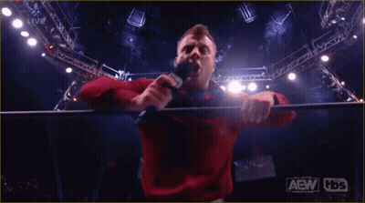 Red Shirt Man Holding Microphone AEW HDS Sign GIF