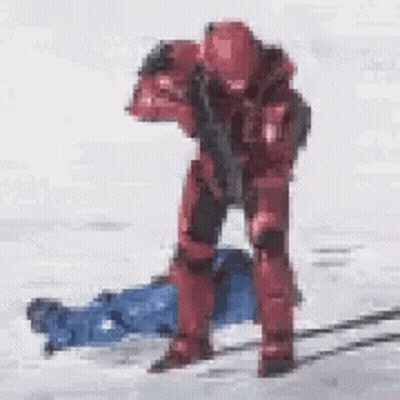 Red Soldier Standing By Laying Person With Gun GIF