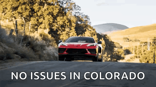 Red Sports Car Driving Down Road With No Issues In Colorado Above It GIF
