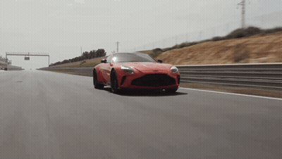 Red Sports Car Driving Past Sign Saying A GIF