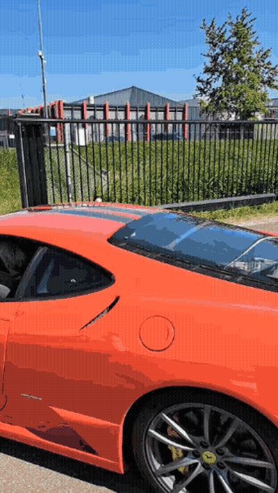 Red Sports Car Parked By Black Fence GIF