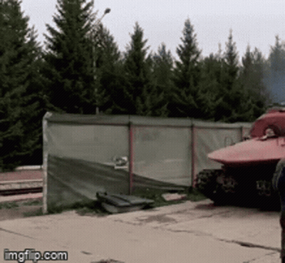 Red Tank Parked By Fence With Trees GIF