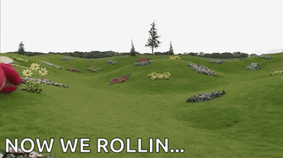 Red Teddy Bear Laying On Grass Saying Now We Rollin GIF