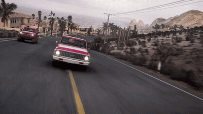 Red Truck Driving Down Desert Road With Mountains GIF