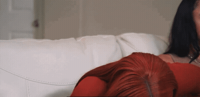 Redhead Laying on White Couch Next to Woman