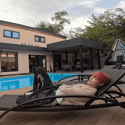 Redhead On Lounge Chair In Front Of House GIF