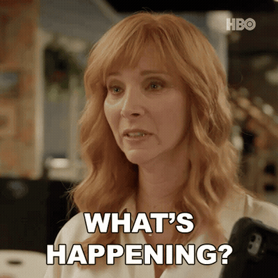 Redhead Woman Holding Cell Phone Saying What's Happening GIF