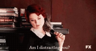 Redhead Woman Holding Feather Saying Am I Distracting You GIF