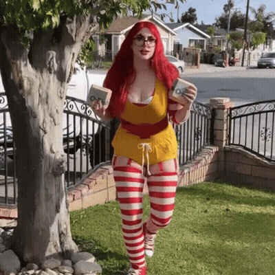 Redhead Woman In McDonald's Costume Standing In Front Of Tree GIF