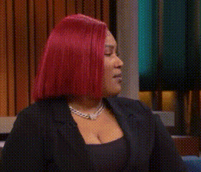 Redhead Woman Sitting On Couch With Hands In Air GIF
