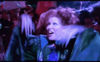 Redhead Woman Standing In Front Of Crowd In Dark Room GIF