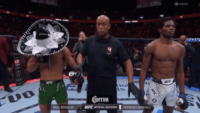 Referee Between Two Fighters In UFC Shorts And Sombrero GIF