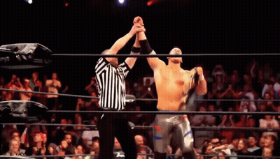 Referee Next To Wrestler Holding Championship Belt GIF