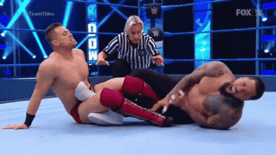 Referee Standing Between Two Men In Wrestling Ring GIF