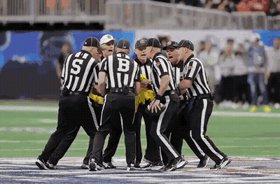 Referees Standing on Football Field