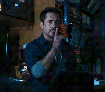 Robert Downey Jr. Is Sitting In A Chair With His Finger To His Lips . GIF