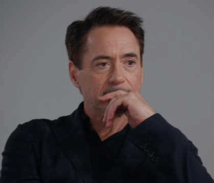 Robert Downey Jr. Is Wearing A Black Suit And Making A Funny Face GIF