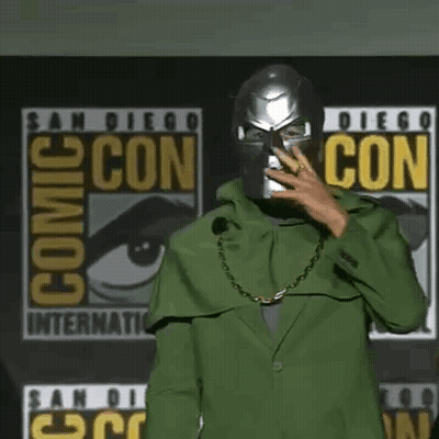 Robert Downey Jr. Is Wearing A Green Cape And A Chain Around His Neck . GIF