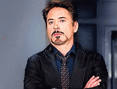 Robert Downey Jr. Is Wearing A Suit And Tie And Has His Arms Crossed . GIF