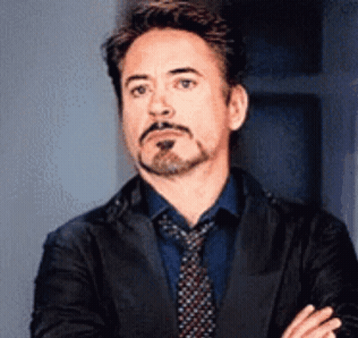 Robert Downey Jr. Is Wearing A Suit And Tie And Making A Funny Face . GIF