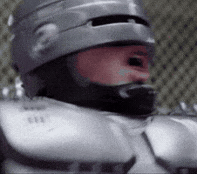 Robot In Suit Giving Thumbs Up In Living Room GIF
