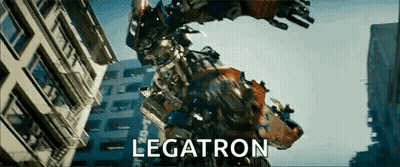Robot Standing In Front Of Legatron Building GIF
