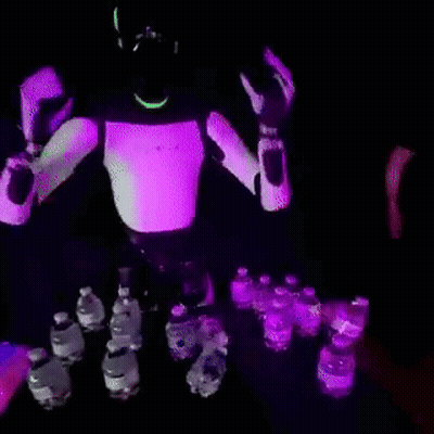 Robot Standing In Front Of Table Full Of Water Bottles GIF