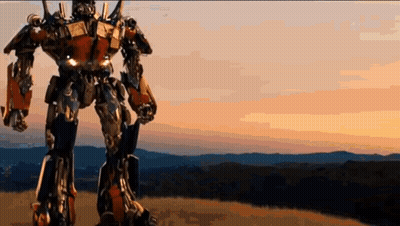 Robot Standing On Hill With Mountains GIF