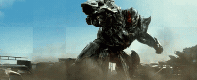 Robot With Gun Standing On Pile Of Cars GIF