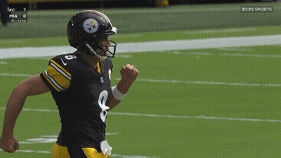 Rodgers Kneeling on Field With Arms in Air
