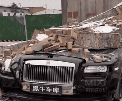 Rolls Royce In Pile Of Bricks Next To Mix Videos Sign GIF