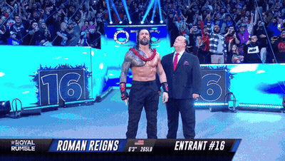 Roman Reigns Is Standing Next To A Man In A Suit In Front Of A Crowd GIF