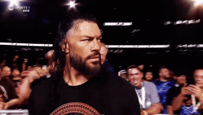 Roman Reigns Is Walking Out Of A Wrestling Ring In Front Of A Crowd GIF