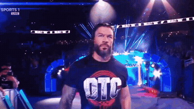 Roman Reigns Is Walking Out Of The Ring Wearing A T-Shirt That Says Gtc On It . GIF