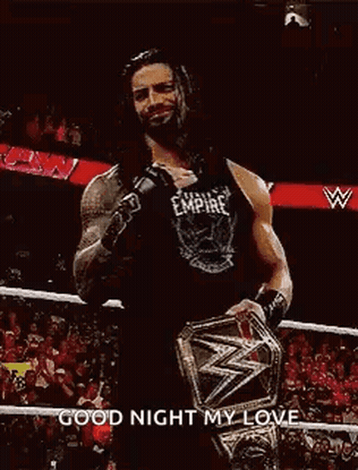 Roman Reigns Is Wearing A Black Tank Top And Holding A Wrestling Championship Belt . GIF